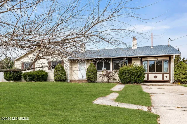 a front view of a house with a yard and potted plants
