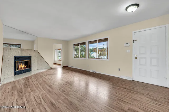 an empty room with windows and a fireplace