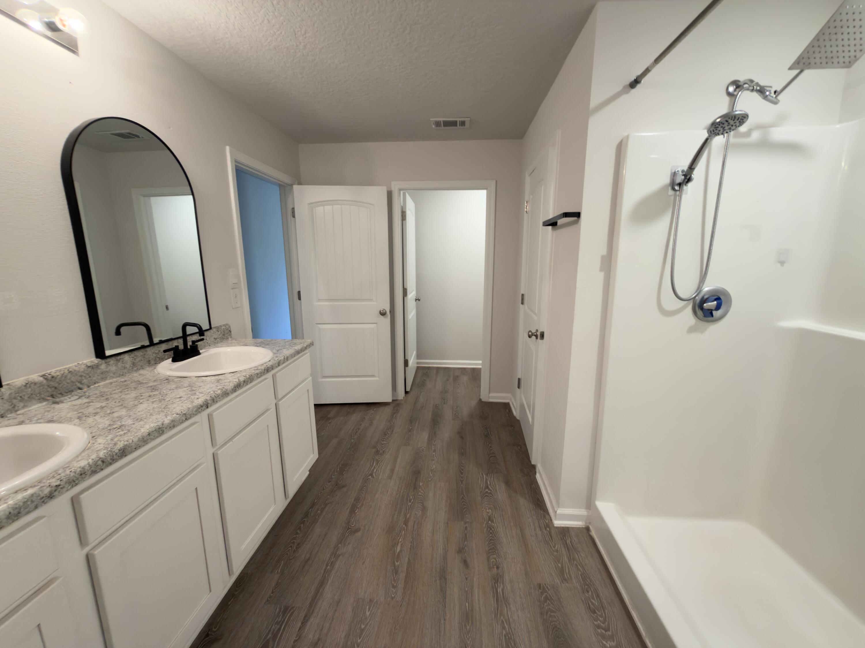 3545 Sugar Maple Lane Crestview, FL 32539 - Photo 12 of 27 a bathroom with a double vanity sink a large mirror a bathtub and shower