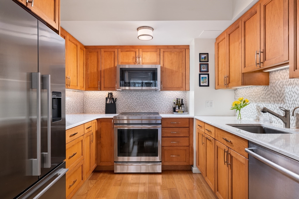 1731 Beacon Street, Unit 402 Brookline, MA 02445 - Photo 6 of 14 a kitchen with stainless steel appliances granite countertop a stove a sink and a refrigerator
