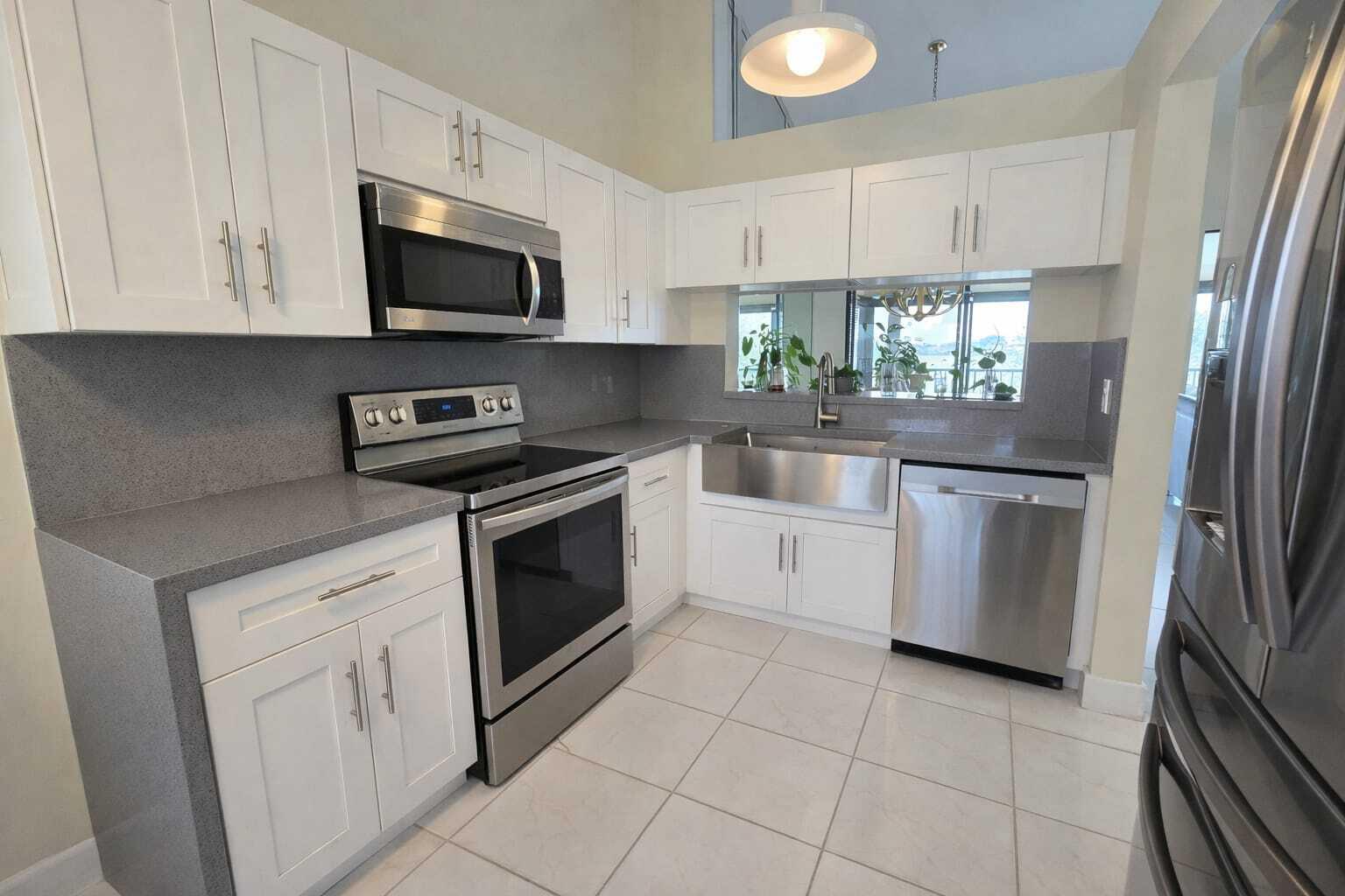 a kitchen with white cabinets stainless steel appliances and a sink