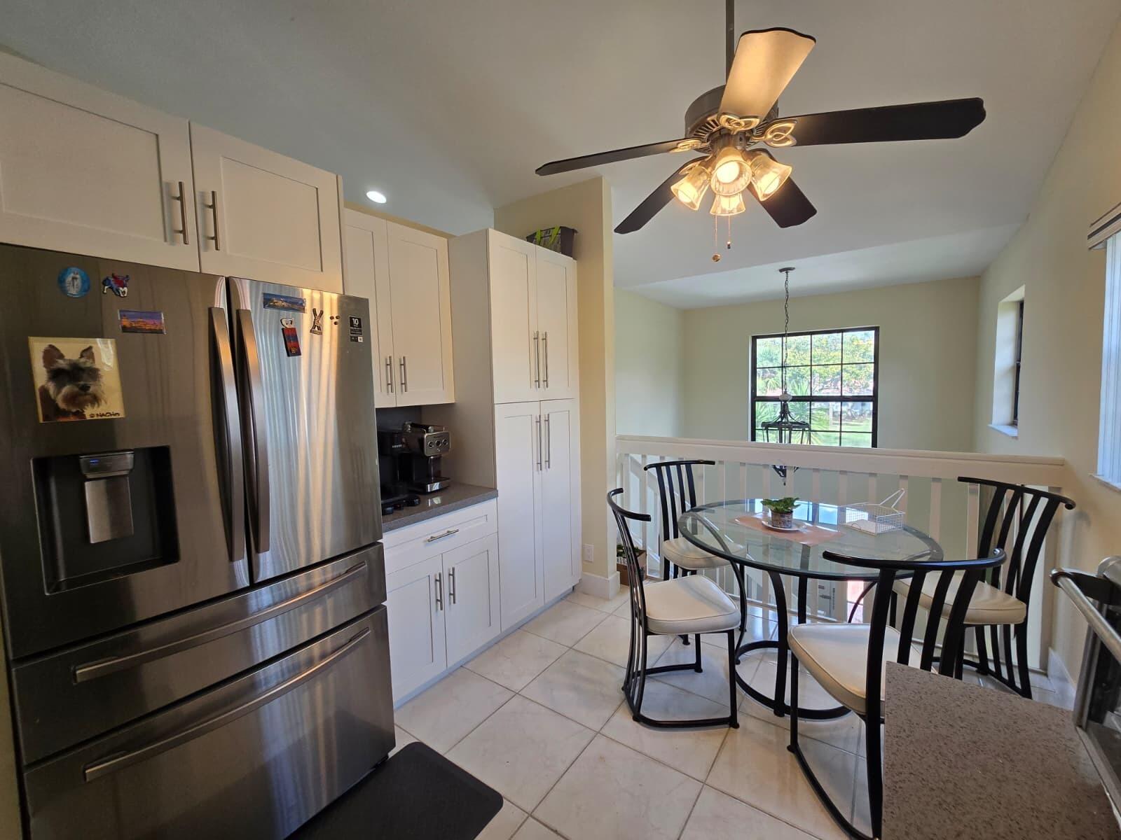 10870 Lakemore Lane, Unit 201 Boca Raton, FL 33498 - Photo 16 of 26 a kitchen with stainless steel appliances granite countertop a dining table and chairs