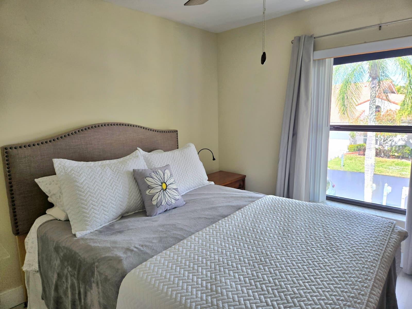 10870 Lakemore Lane, Unit 201 Boca Raton, FL 33498 - Photo 19 of 26 a large bed sitting in a bedroom next to a window