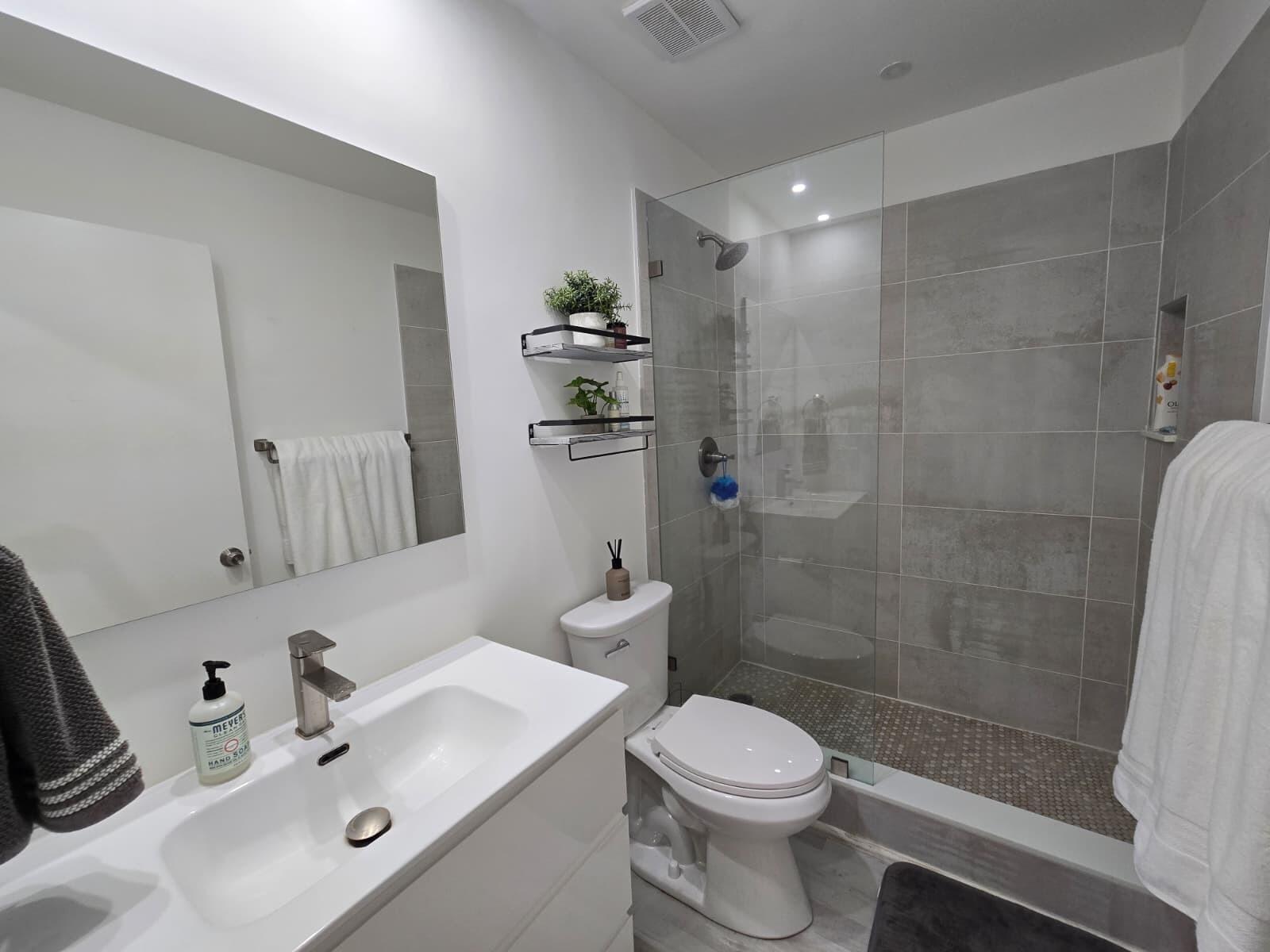 10870 Lakemore Lane, Unit 201 Boca Raton, FL 33498 - Photo 20 of 26 a bathroom with a sink a toilet and shower