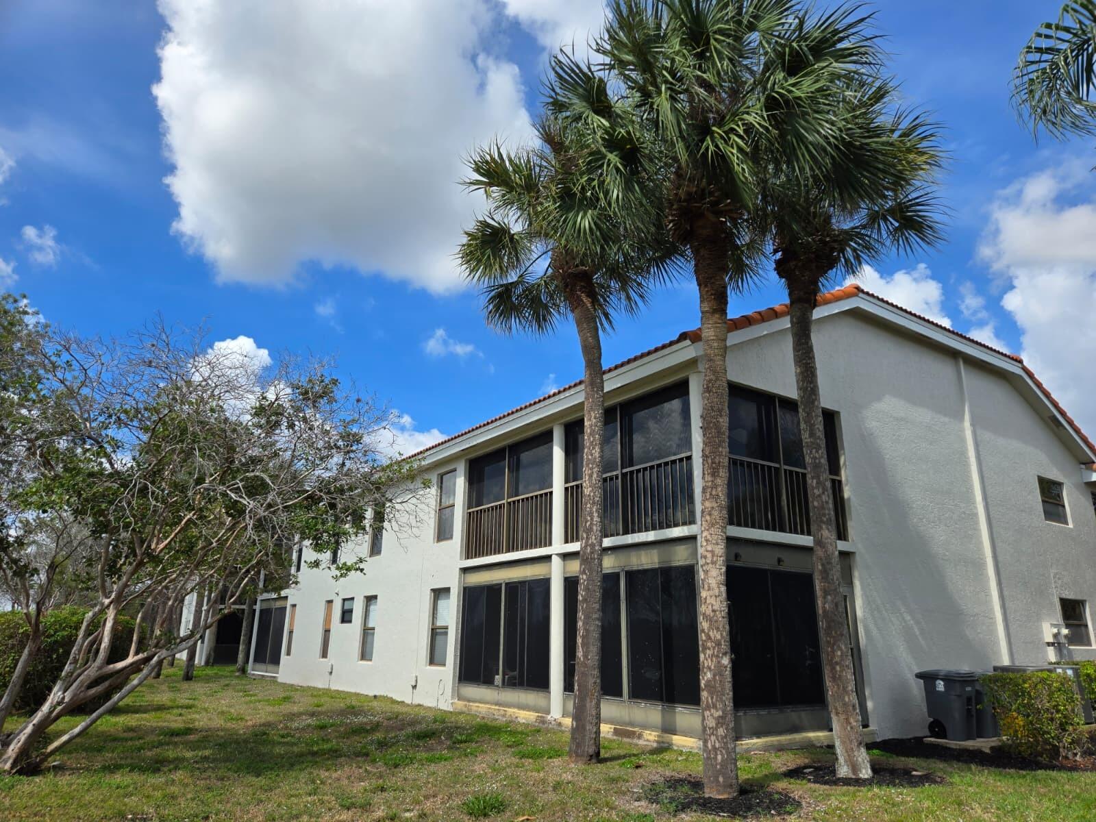 10870 Lakemore Lane, Unit 201 Boca Raton, FL 33498 - Photo 2 of 26 a view of a house with a yard