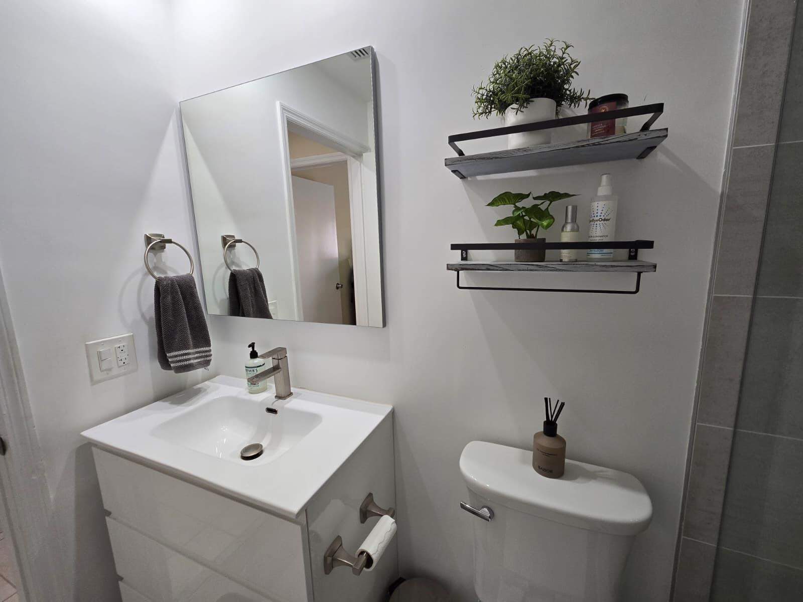 10870 Lakemore Lane, Unit 201 Boca Raton, FL 33498 - Photo 21 of 26 a bathroom with a toilet sink and mirror