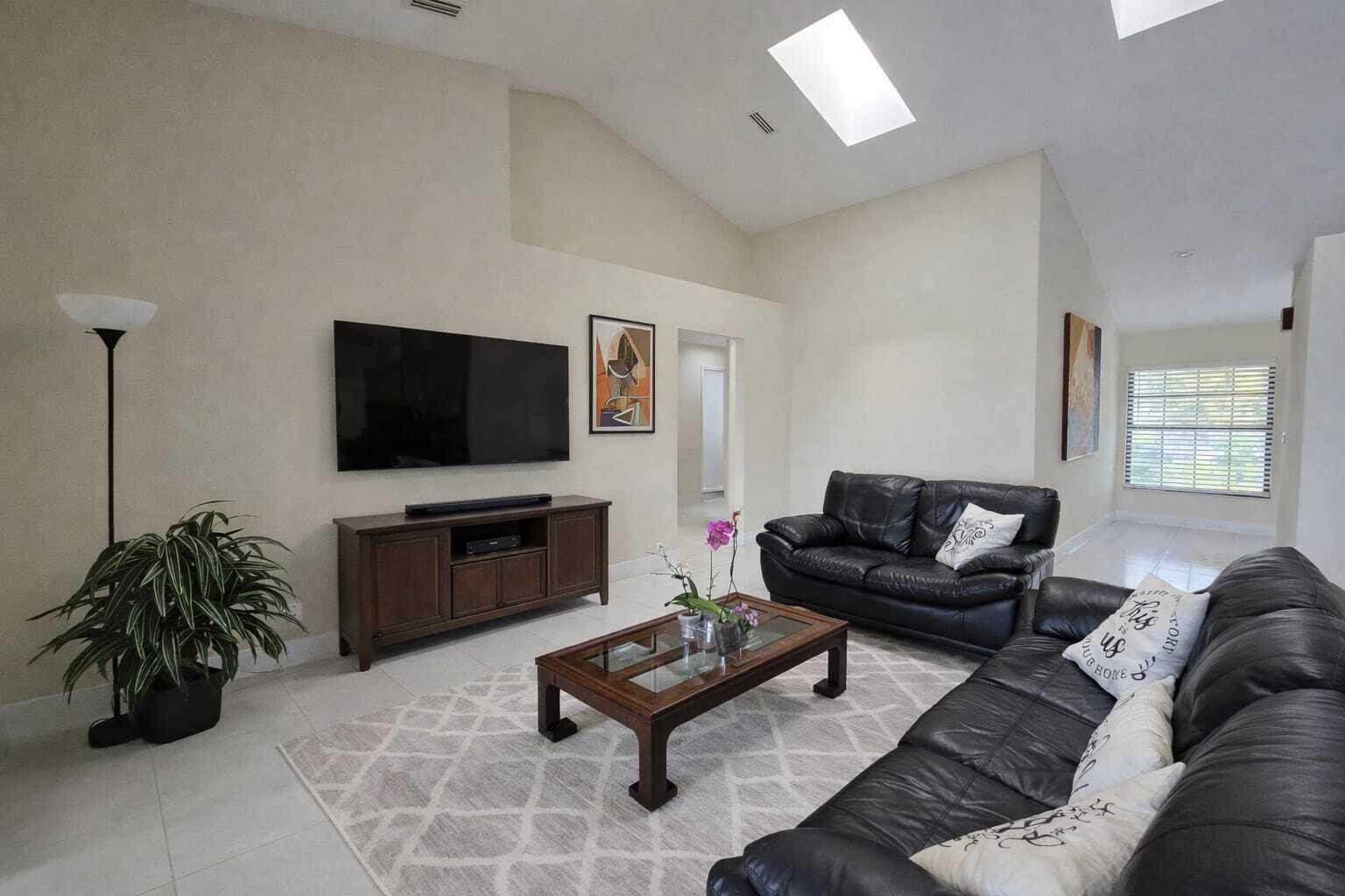 10870 Lakemore Lane, Unit 201 Boca Raton, FL 33498 - Photo 7 of 26 a living room with furniture and a flat screen tv