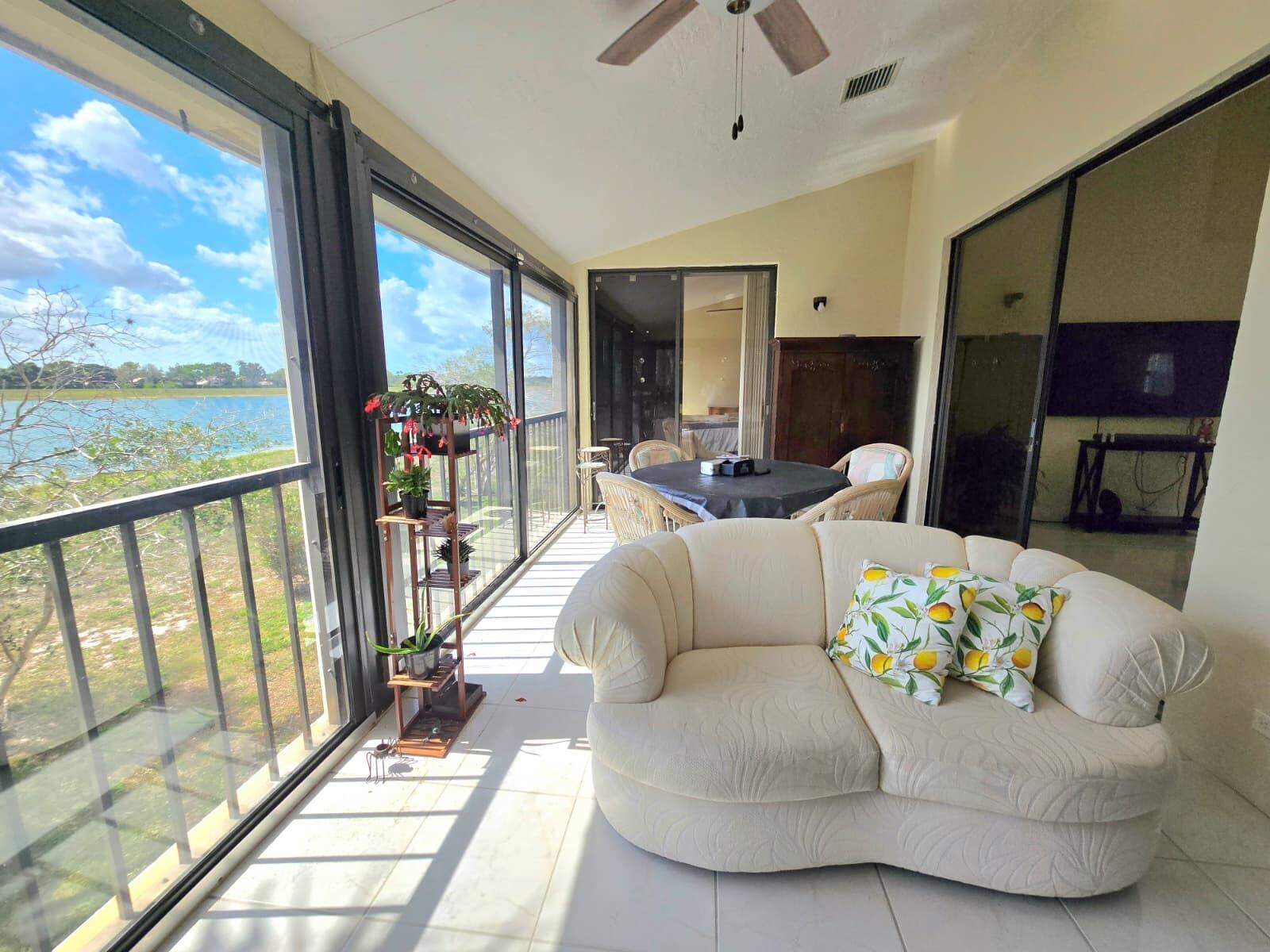 10870 Lakemore Lane, Unit 201 Boca Raton, FL 33498 - Photo 9 of 26 a living room with furniture and a floor to ceiling window