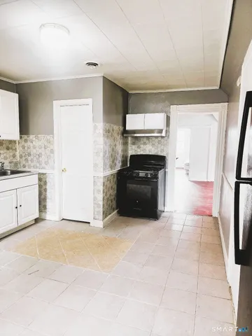 a large kitchen with a stove a sink dishwasher and a refrigerator