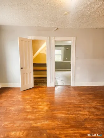 a view of empty room with wooden floor