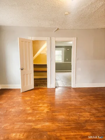 a view of empty room with wooden floor