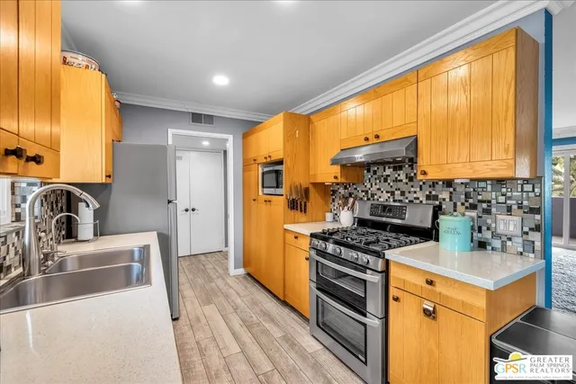 a kitchen with stainless steel appliances a stove a sink and a refrigerator