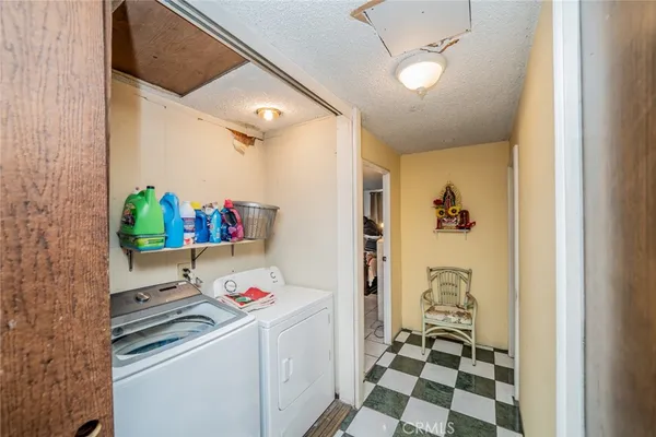 a utility room with a refrigerator and a sink