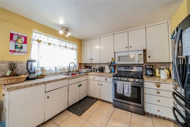 a kitchen with a sink stove and white cabinets