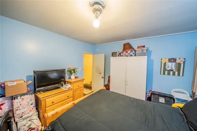 a bedroom with furniture and a flat screen tv