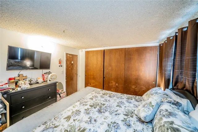 a bedroom with a bed and flat screen tv