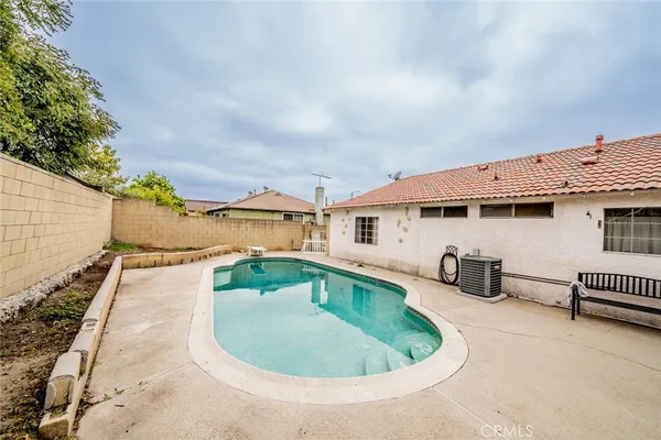 an aerial view of a house with swimming pool and furniture