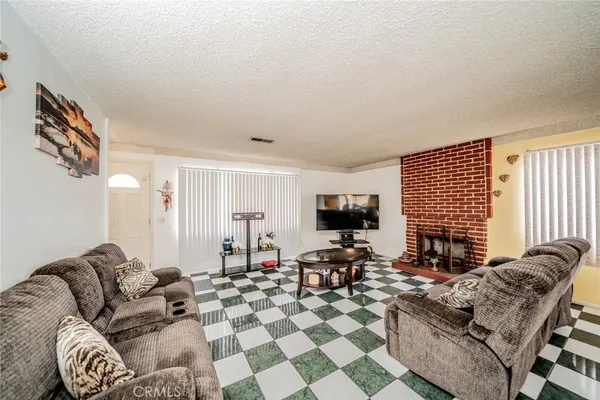 a living room with furniture a flat screen tv and a window