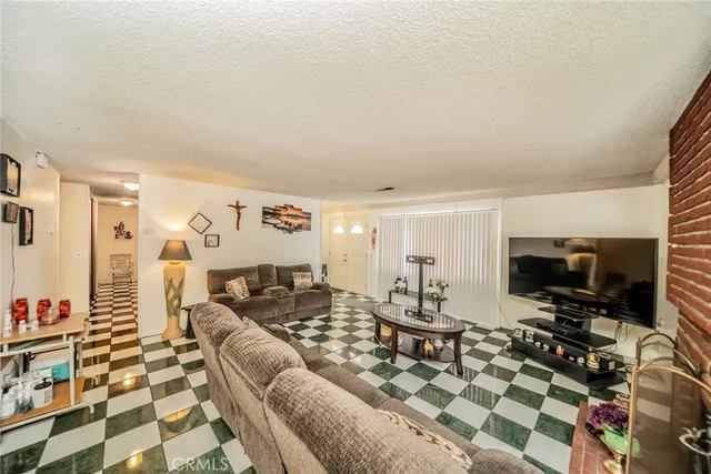 a living room with furniture a flat screen tv and a table