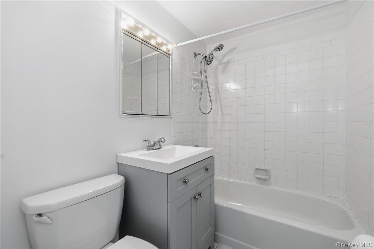 250 Shore Road, Unit 4D Long Beach, NY 11561 - Photo 9 of 16 a bathroom with a sink a toilet and shower