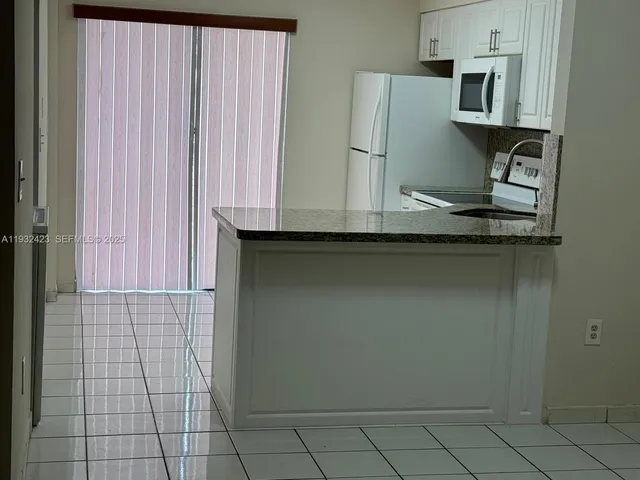 a kitchen with cabinets and a refrigerator