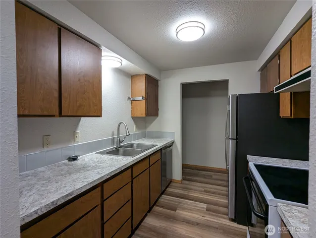 a kitchen with stainless steel appliances granite countertop a sink and a refrigerator
