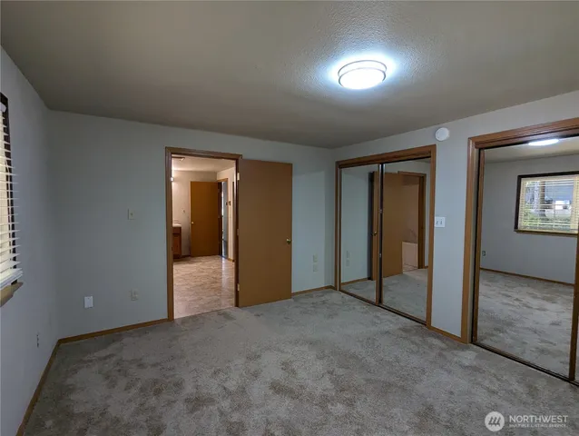 an empty room with closet and mirror