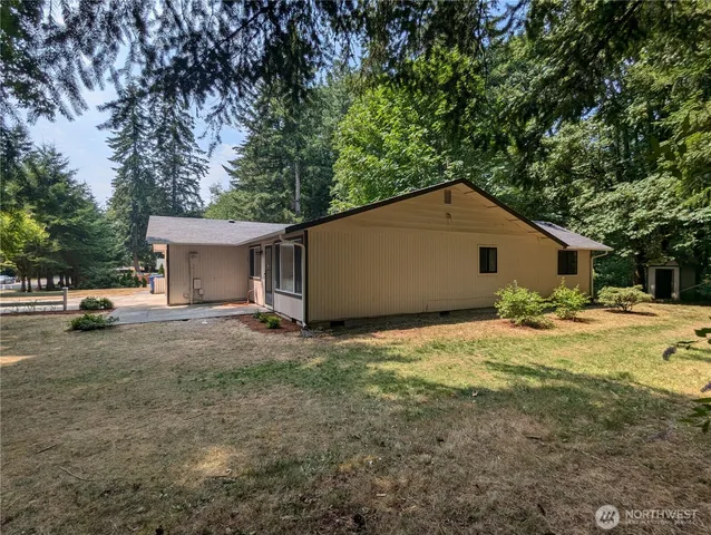 a view of a house with backyard and a tree