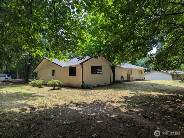a house is sitting in middle of the middle of the forest