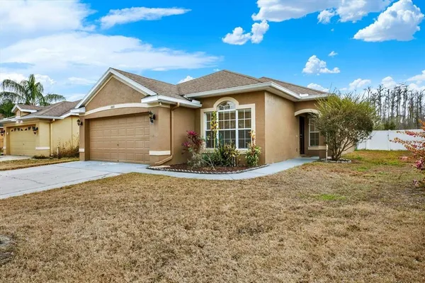 a view of a house next to a yard and a garage