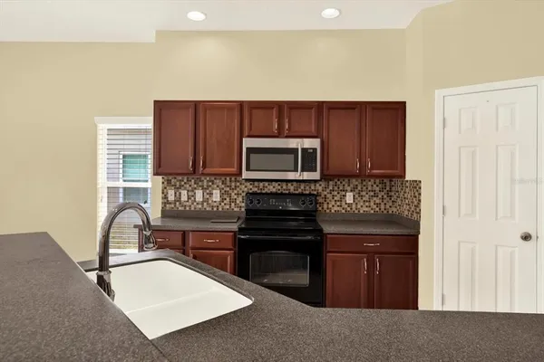 a kitchen with stainless steel appliances granite countertop a sink and a stove