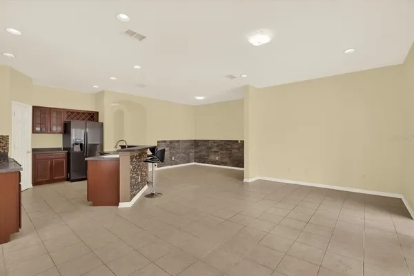 a kitchen with stainless steel appliances granite countertop a stove a sink a refrigerator a dining table and chairs