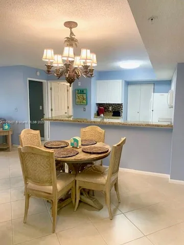 a kitchen with a dining table chairs and white cabinets