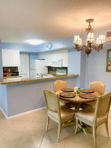 a bathroom with a granite countertop sink a mirror and a bathtub