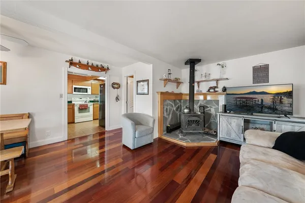 a living room with stainless steel appliances furniture a rug and a kitchen view