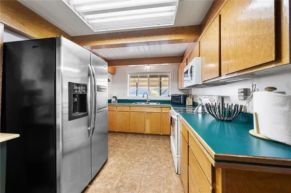 a kitchen with stainless steel appliances granite countertop a refrigerator and a sink