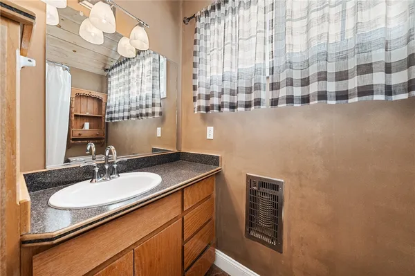 a bathroom with a granite countertop sink and a mirror