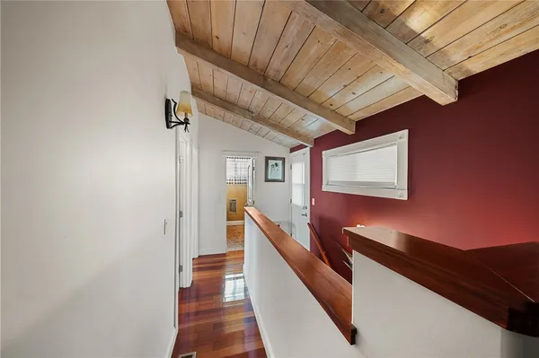 a hallway with wooden floor and staircase