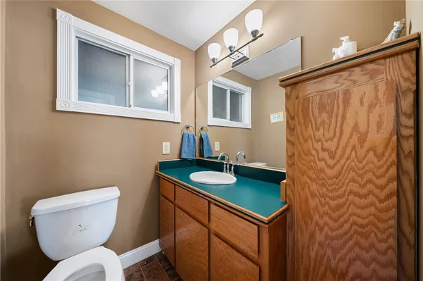 a bathroom with a toilet sink and mirror