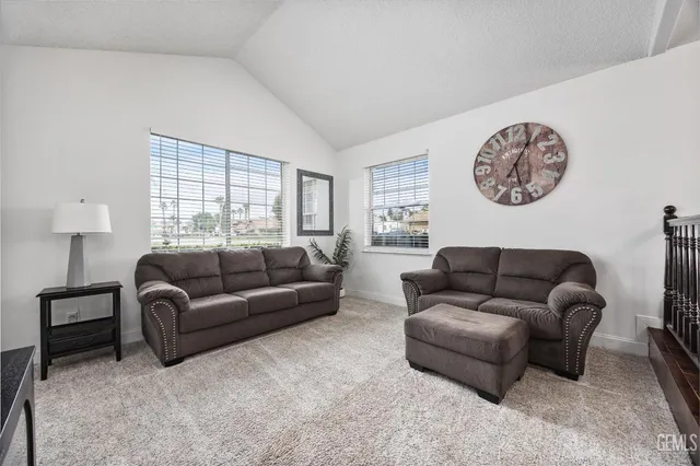 a living room with furniture a chandelier and a large window