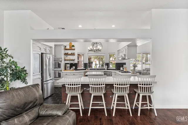 a large white kitchen with a large island in the center