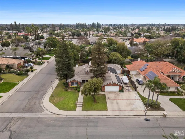 an aerial view of a house with a garden and lake view