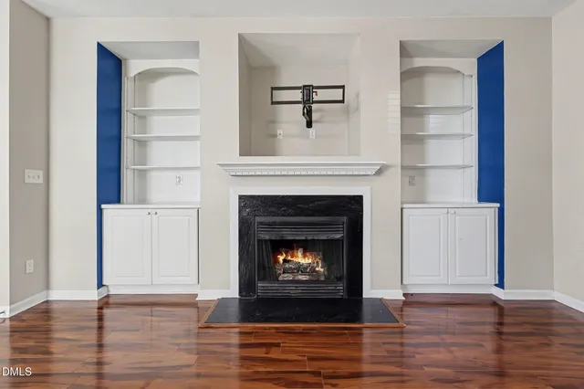 a view of empty room with wooden floor and a fireplace