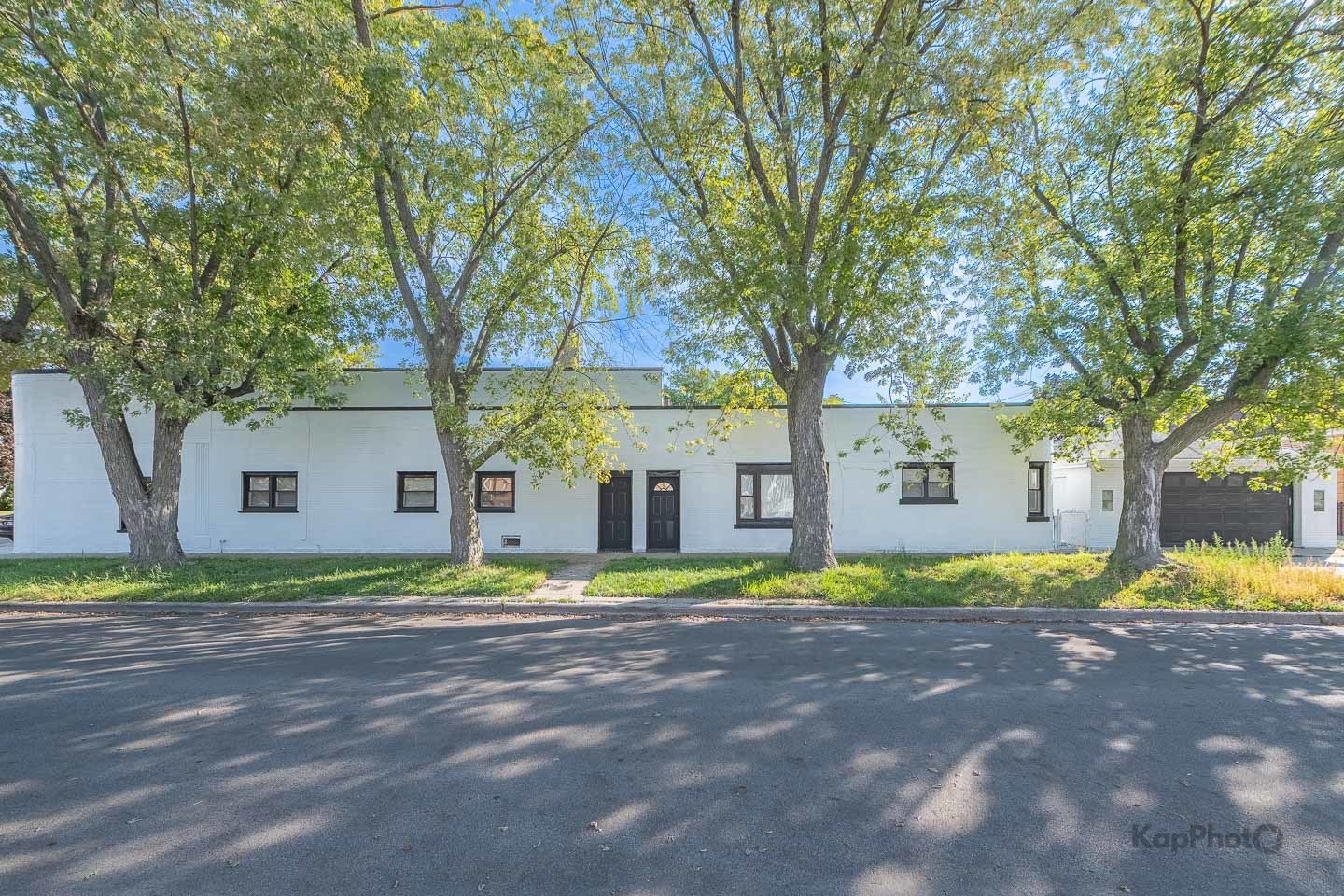 a front view of a house with a yard and trees