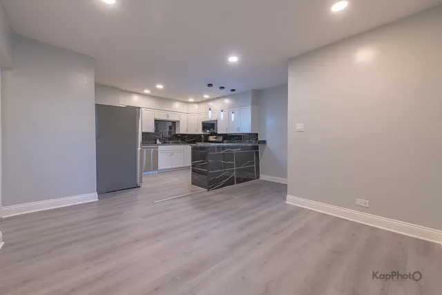 a view of a kitchen with a sink and a refrigerator