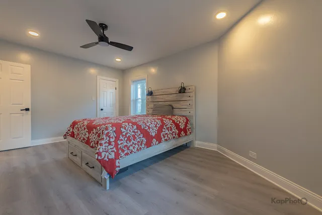 a bedroom with a bed and a ceiling fan