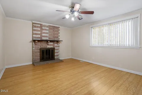 a view of an empty room with a fireplace and a window