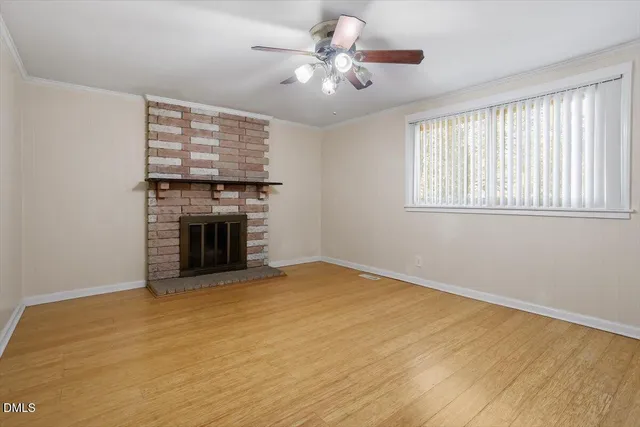 a view of an empty room with a fireplace and a window