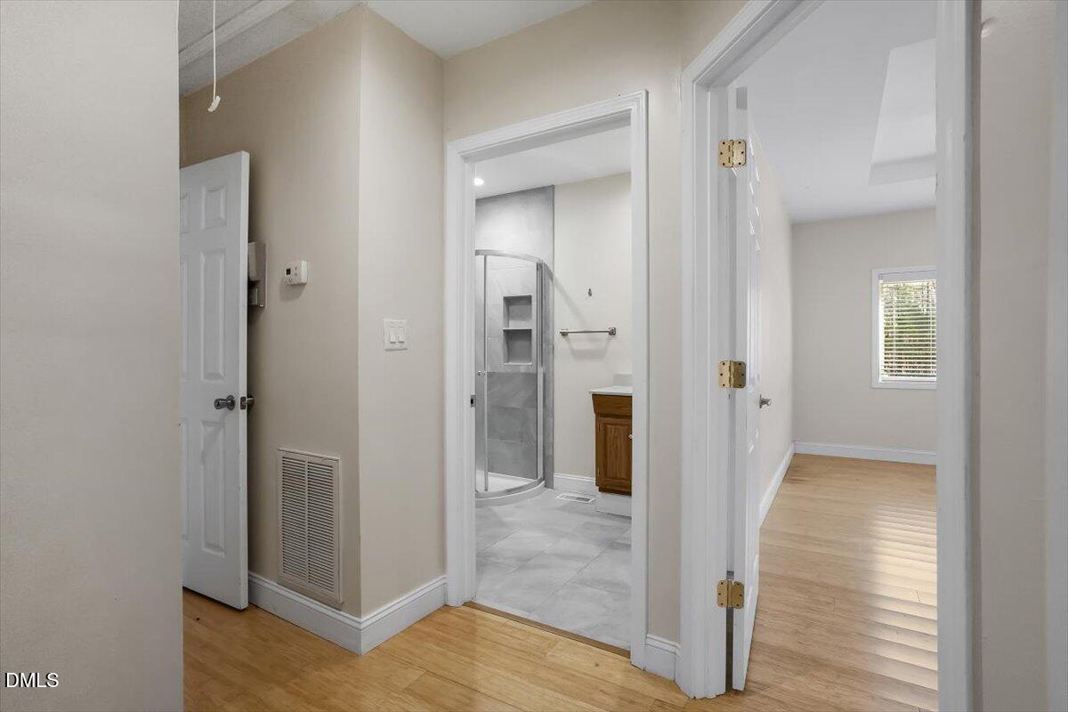 2903 Neville Road Chapel Hill, NC 27516 - Photo 13 of 47 a view of a hallway with wooden floor and a bathroom