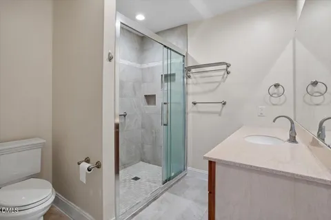 a bathroom with a granite countertop sink toilet and shower